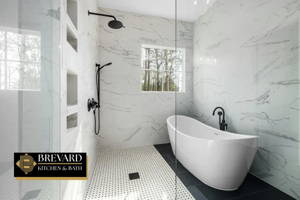 Walk-in shower with marble tile next to a freestanding tub