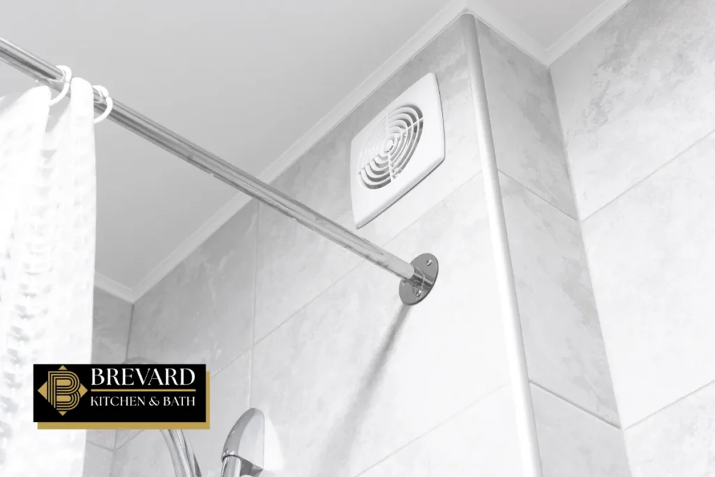 Wall-mounted bathroom ventilation fan above a shower rod